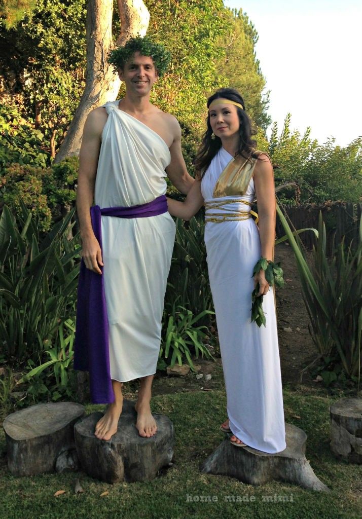 a man and woman dressed in ancient greek costumes standing next to each other holding hands