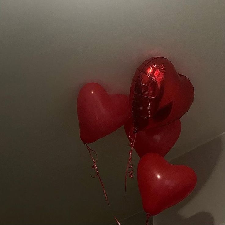 some red heart shaped balloons hanging from the ceiling