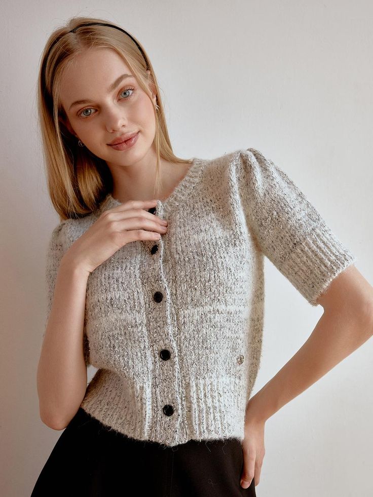 This product is a delicate half cardigan that offers both warmth and style. Featuring a classic button-up front and a cozy knit texture, this cardigan is perfect for layering over a variety of outfits. The short sleeves make it a versatile choice for different seasons and settings. The cardigan's button-up front allows for easy adjustment, making it perfect for a snug fit or a more relaxed look.Its knit texture provides a touch of elegance and comfort, suitable for day-to-day wear.The short Knit Cardigan With Buttons For Daywear, Elegant Fitted Cardigan With Short Sleeves, Fitted Knit Top With Button Closure, Knit Short Sleeve Sweater For Fall, Knit Sweater With Short Sleeves For Fall, Short Sleeve Knit Sweater For Fall, Cozy Fitted Cardigan With Button Closure, Classic Short Sleeve Sweater For Fall, Chic Fitted Short Sleeve Cardigan