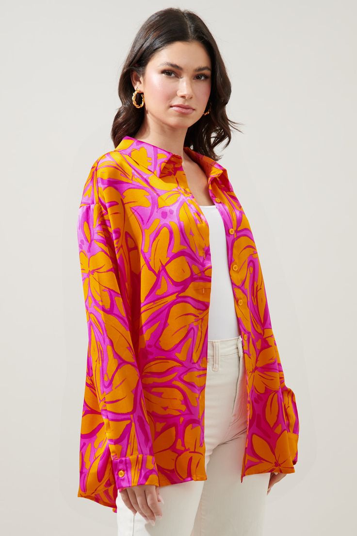 Sweet and spicy, just like this shirt. A vibrant orange floral lays against a fuchsia-ground on satin to shape the Dalton shirt. A classic button front with a relaxed, boyfriend fit. It's drop shoulder and wide frame allow for layering and styling. Wear it layered over a ribbed tank or swim suit.- Satin- Functional buttons- Oversized- Boyfriend fit- Color: Fuchsia OrangeSize + Fit - Model is 5'9" and wearing size XS- Measurements taken from size S - Chest: 25"- Length: 29 1/2" Fabric Self:100% P Orange Floral Print Shirt For Spring, Relaxed Fit Orange Blouse With Floral Print, Orange Relaxed Fit Blouse With Floral Print, Orange Floral Print Relaxed Fit Blouse, Chic Orange Shirt For Spring, Spring Shirt With Vibrant Print, Spring Vibrant Button-up Blouse, Vibrant Spring Button-up Blouse, Vibrant Printed Spring Shirt