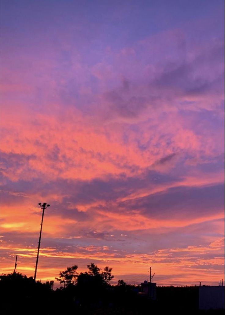 the sky is pink and purple as the sun sets