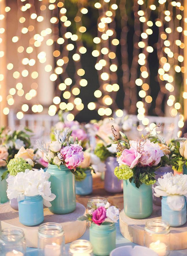 there are many vases with flowers in them on the table at this wedding reception