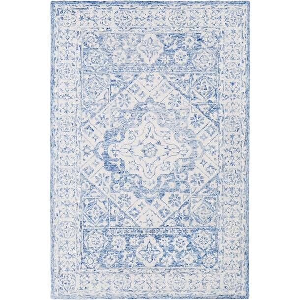 a blue and white rug with an intricate design on the bottom, in front of a white background