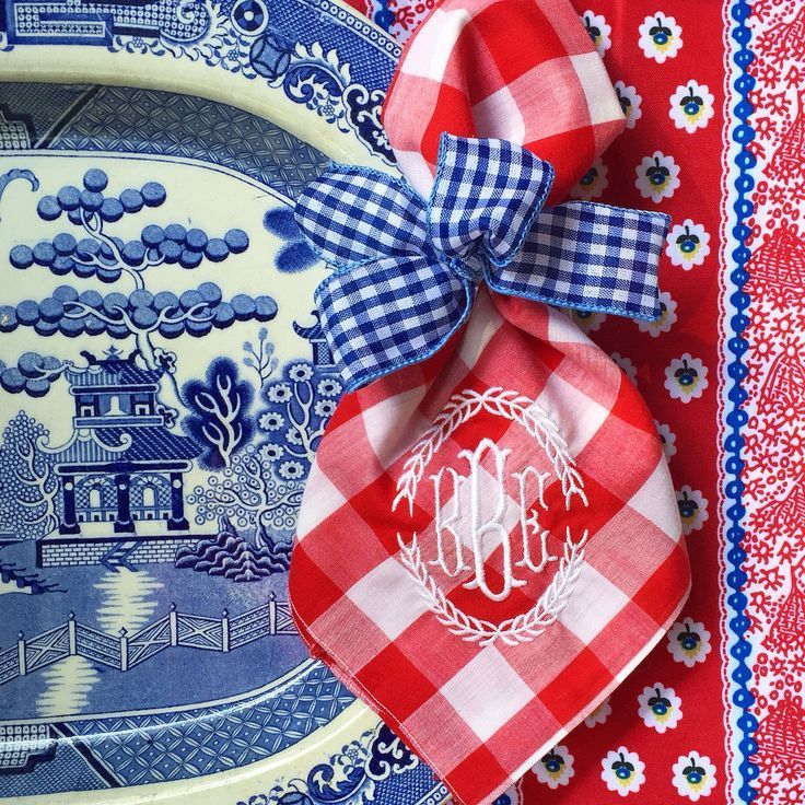 the monogrammed napkins are tied on top of blue and white china plates