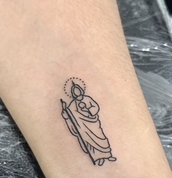 a small tattoo on the ankle of a person with a rosary in her hand and an angel