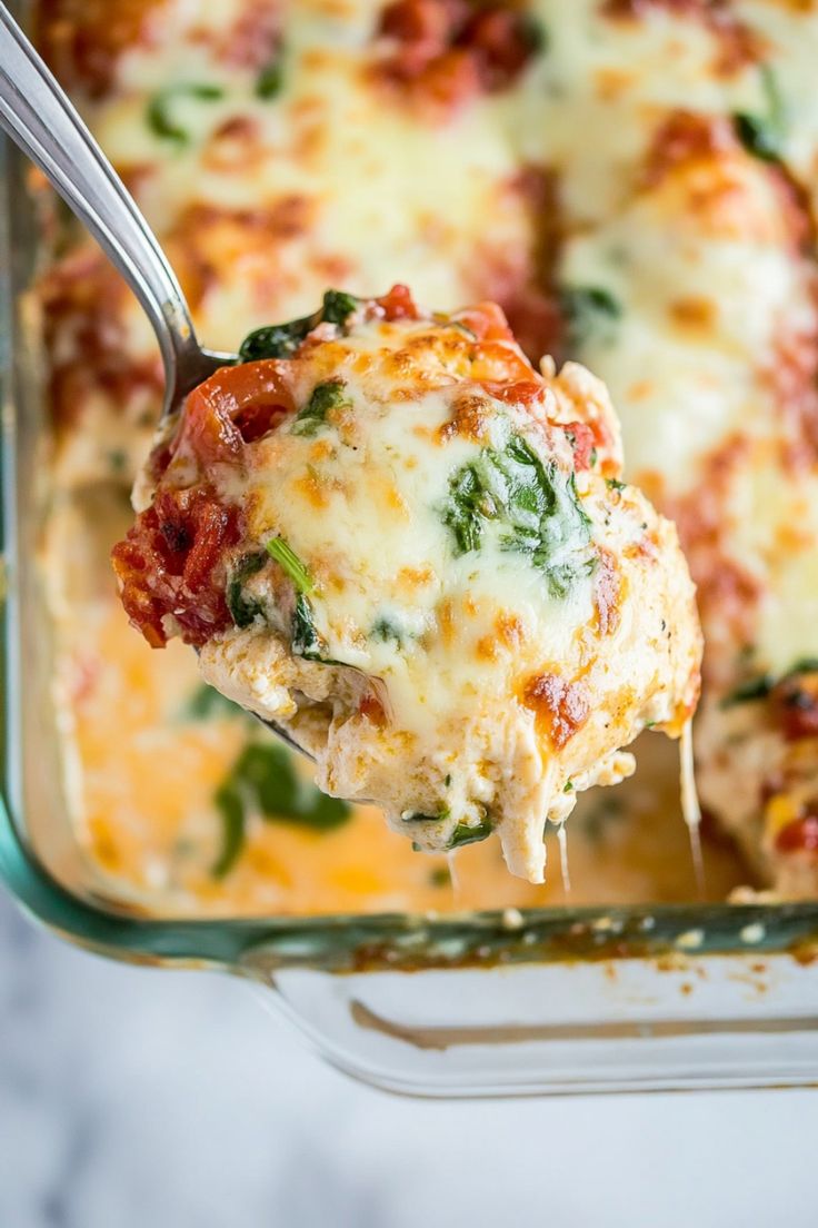 a spoon full of lasagna casserole with spinach and cheese