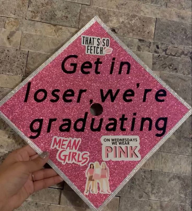 a pink graduation cap that says, get in lose we're graduating