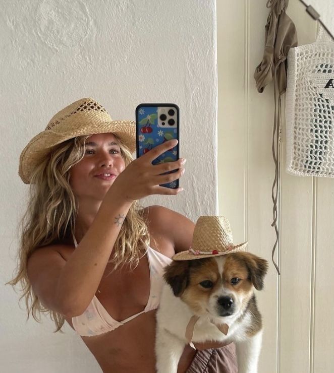 a woman taking a selfie with her dog and cell phone in front of her