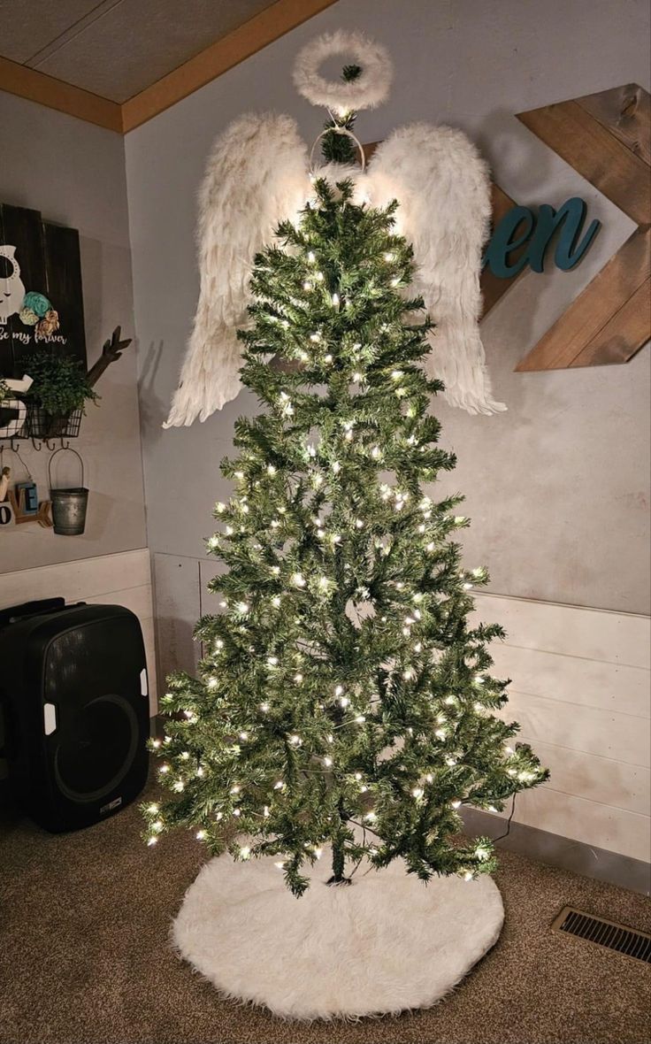 an artificial christmas tree with angel wings on top