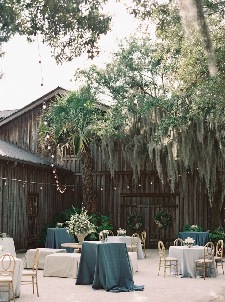 tables and chairs are set up in front of a barn