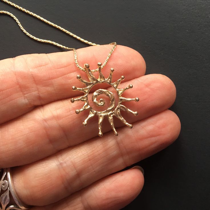 "This is now the largest sun I currently make in gold; it measures 1-1/16\" tall by 7/8\" wide (27x22mm) and is quite a bit heavier thank the \"Large\" sun version. Hot summer sun in solid recycled 14k gold! (Melted down old pieces, not newly mined out of the ground). This is my design that I made here in my studio. I sculpt the shape out of jewelers wax, and using a kiln, torch and centrifuge; cast it into solid 14k gold. I offer this pendant alone or with a beautiful 18\" solid 1mm 14k Wheat c Unique Necklace With Large 14k Gold Pendant, Unique 14k Gold Necklace With Large Pendant, Gold Jewelry With Sun Design In 14k Gold, 14k Yellow Gold Jewelry With Sun Design, Sterling Silver Jewelry With Sun Design In Yellow Gold, 14k Yellow Gold Sun Design Jewelry, 14k Gold Necklaces With Sun Design, 14k Yellow Gold Sun Design Necklace, Yellow Gold Brass Jewelry With Sun Design