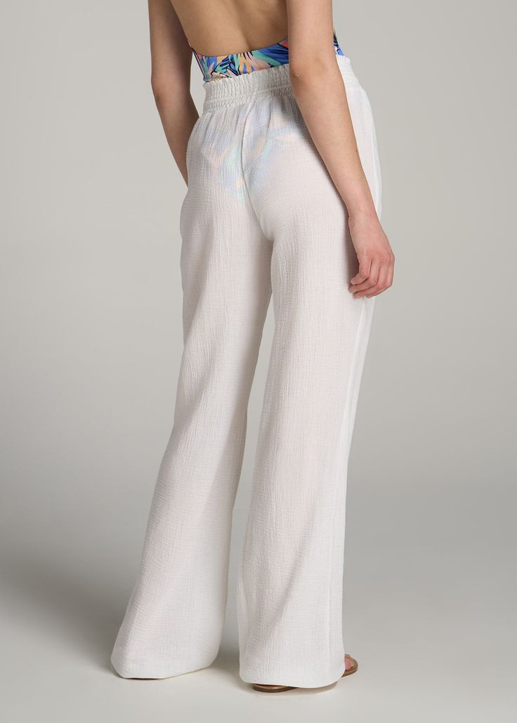 Breezy Elegance in Women's Tall Pants The Perfect Blend of Comfort and Style Our Gauze Cover Up Tall Women's Pants offer up a flowy fashion statement for ladies who aren't afraid to show some flair. With a wide leg and relaxed fit, they're perfect for sunny days and beach getaways. So, enjoy a look that enhances your longer legs and screams style, even at your most relaxed.• Full length, wide-leg design for a relaxed fit• Elastic waist with wooden bead accents• Lightly gathered waistband for a f Beach Season Wide-leg Loungewear Pants, White Wide-leg Pants For The Beach, White Non-stretch Pants For Beach, White Summer Beach Cover-up Pants, Non-stretch Cotton Beach Pants, Tall Pants, Tall Women, Long Legs, Bright White