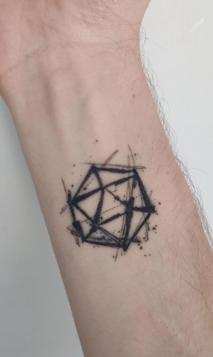 a small black diamond tattoo on the left side of the arm and wrist, it appears to be inked