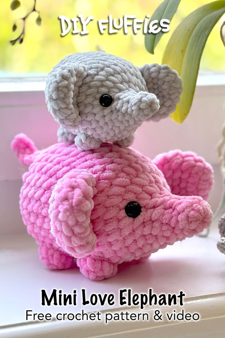 a crocheted elephant sitting on top of a window sill next to a plant