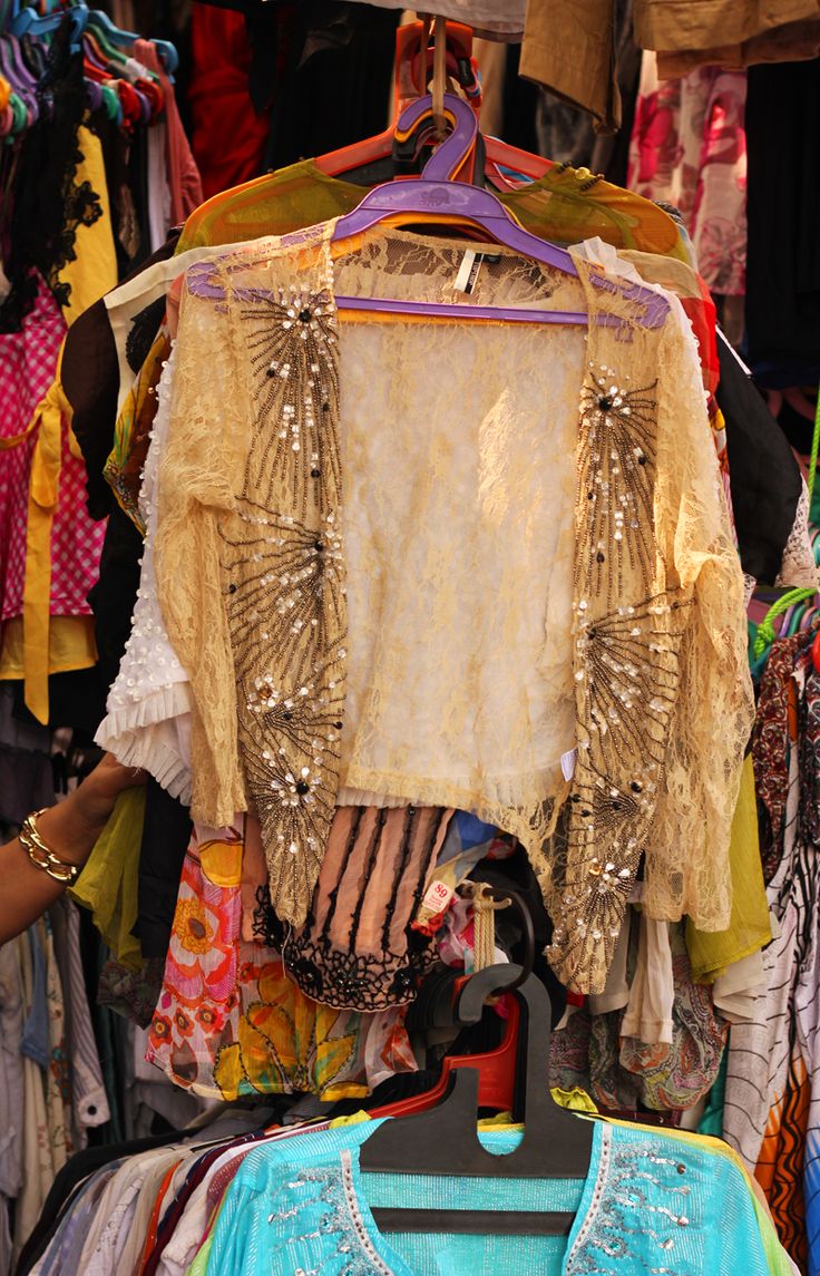 an assortment of clothing on display at a market