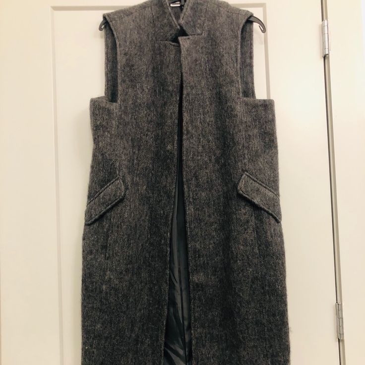 Size Large, Gray Long Waistcoat, Sleeveless, Wool Blend, Fully Lined Interior, Never Worn Practical For Cooler Weather Fitted Sleeveless Outerwear For Fall, Fall Sleeveless Vest Outerwear, Sleeveless Vest Outerwear For Fall, Sleeveless Vest For Fall, Wool Sleeveless Outerwear For Work, Sleeveless Wool Outerwear For Work, Fall Wool Vest With Pockets, Sleeveless Fall Workwear Outerwear, Sleeveless Outerwear For Fall Workwear