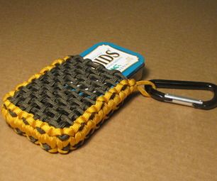 a yellow and black cell phone case sitting on top of a brown table next to a pair of scissors