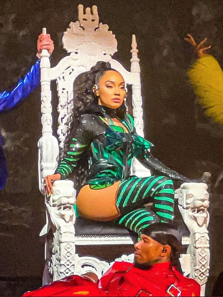 a woman sitting on top of a white chair next to a man in red and blue