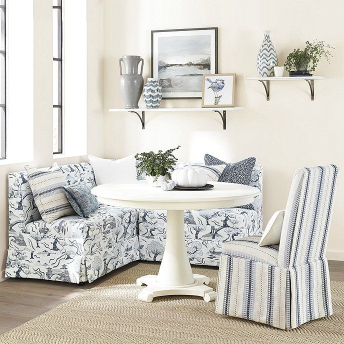 a living room with blue and white furniture on the floor, couches and chairs