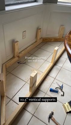 tools are laying on the floor in front of a window and some wood planks