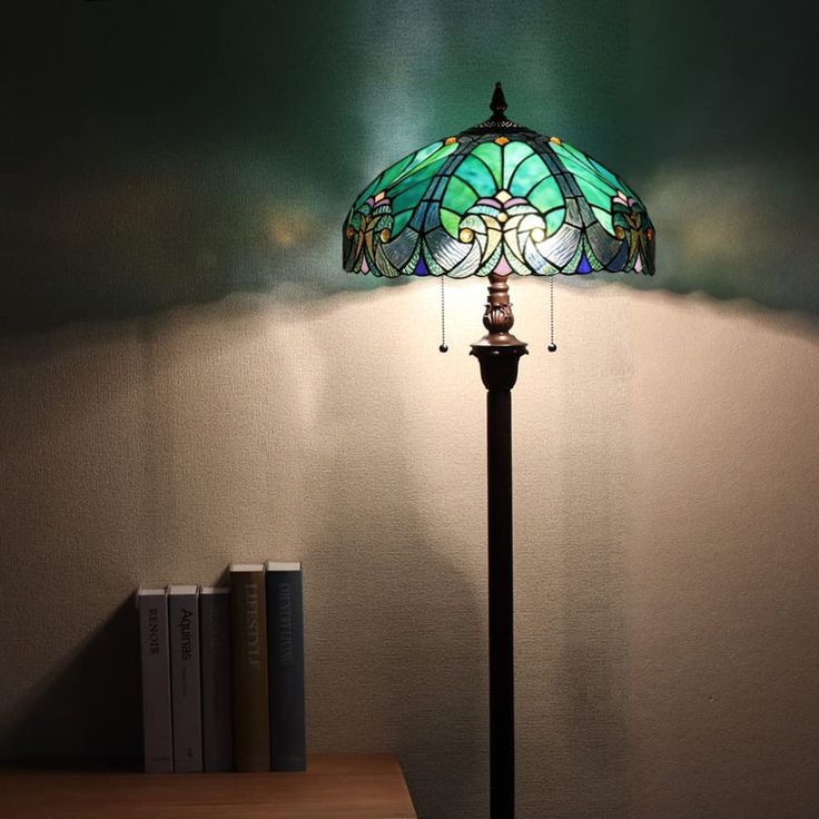 a lamp sitting on top of a wooden table next to a book shelf with books