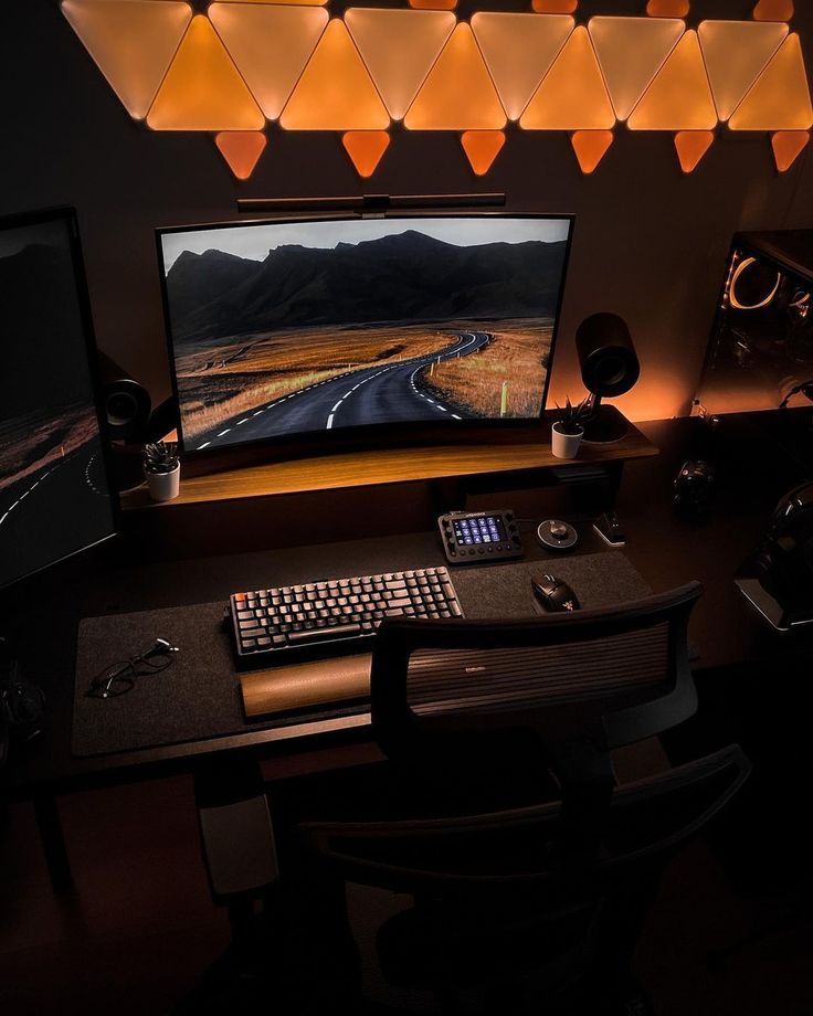 a computer desk with a monitor, keyboard and mouse on it in front of some lights