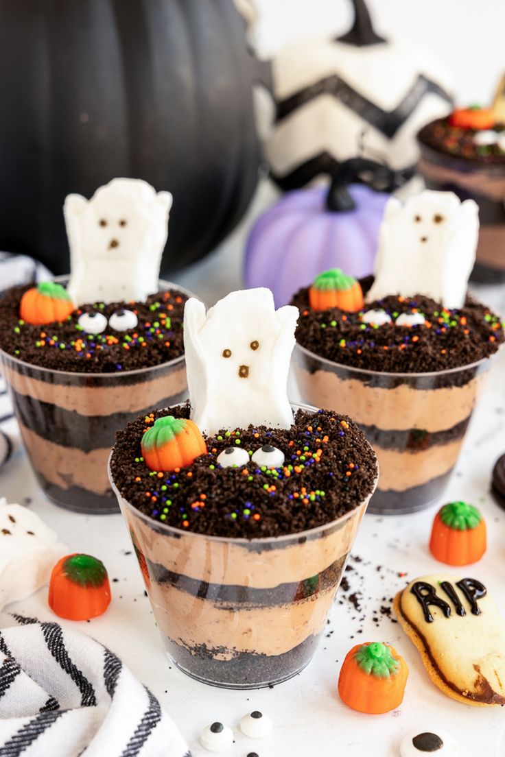 three dessert cups with halloween treats in them