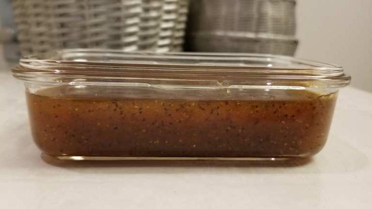 a glass container filled with sauce sitting on top of a counter