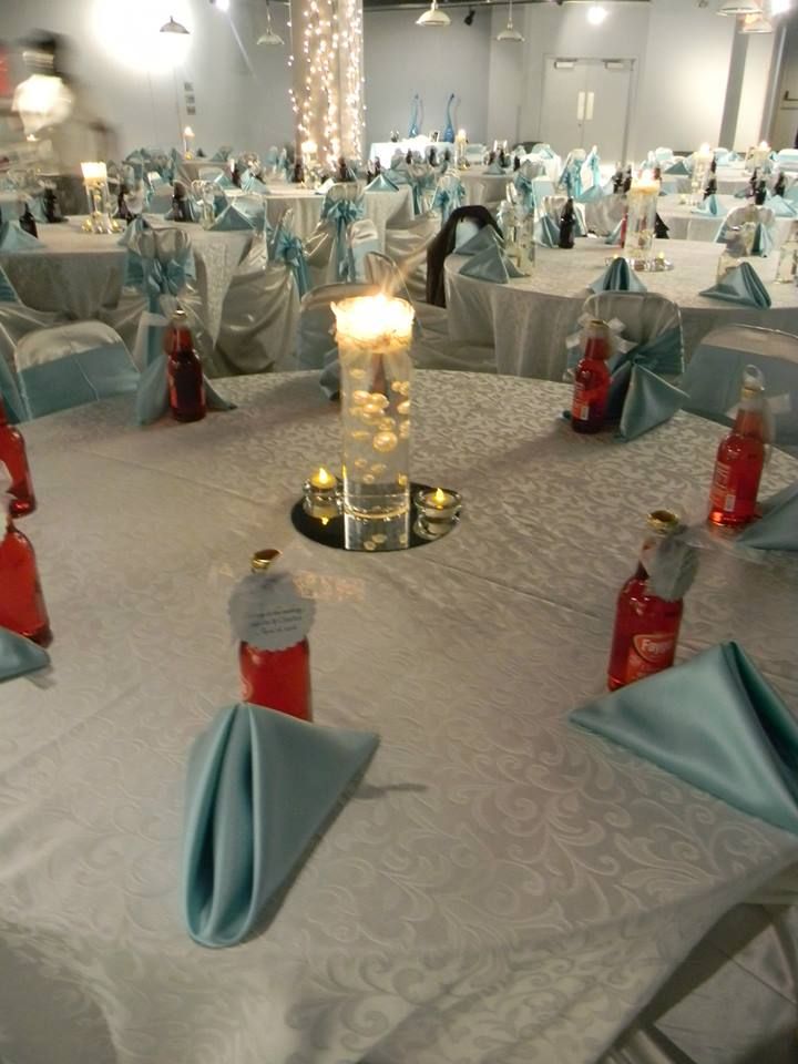 the tables are set up with blue and white linens, silver tablecloths, and candles