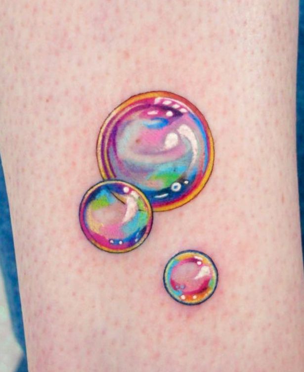 two soap bubbles on the side of a woman's leg