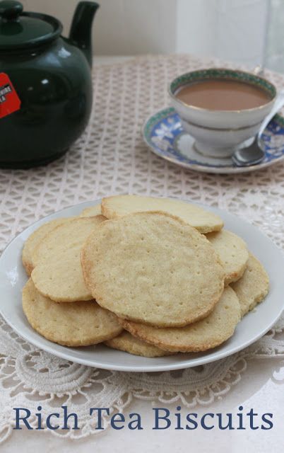 a white plate topped with cookies next to a cup of tea