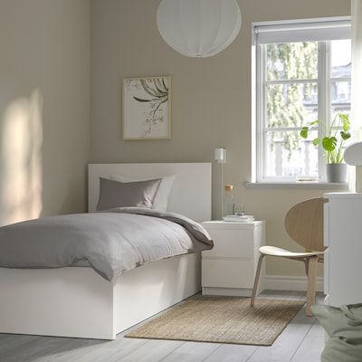 a bedroom with a bed, desk and chair next to a window in the room