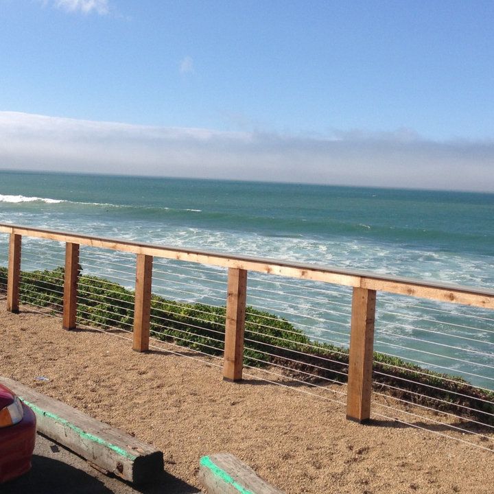 a car parked on the side of a road next to an ocean with waves coming in