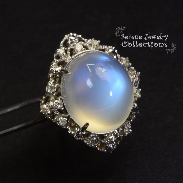 This large rare Moonstone Cabochon Ring is set in 14k solid gold and exhibits mesmerizing blue flash aduralescence. Scintillating diamonds surround this natural beauty! Ring Size: 5.75 Total Weight: 13.65 grams Precious Metal: 14k solid gold Precious stones: -Moonstone Center Stone: 18.5mm x 16.2mm, 23.05 carats -White Round Diamond: 0.4ct Mystical Cabochon Jewelry For Anniversary, Fine Jewelry White Gold Moonstone Cabochon Ring, Celestial Cabochon Jewelry For Anniversary, Elegant Multi-stone Moonstone Ring, Fine Jewelry Moonstone Cabochon Ring, Unique Moonstone Ring With Accent Stones, Elegant Collectible Moonstone Ring, Luxury Multi-stone Round Moonstone Ring, Unique Diamond Moonstone Ring