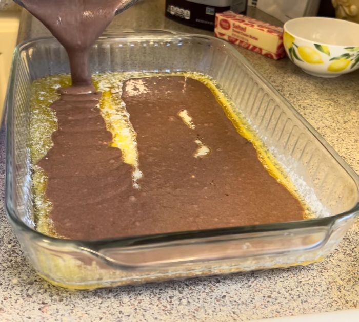 someone is pouring chocolate into a baking dish