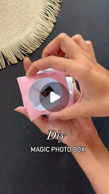 a person holding a pink object in their hand with the text diy magic photo box