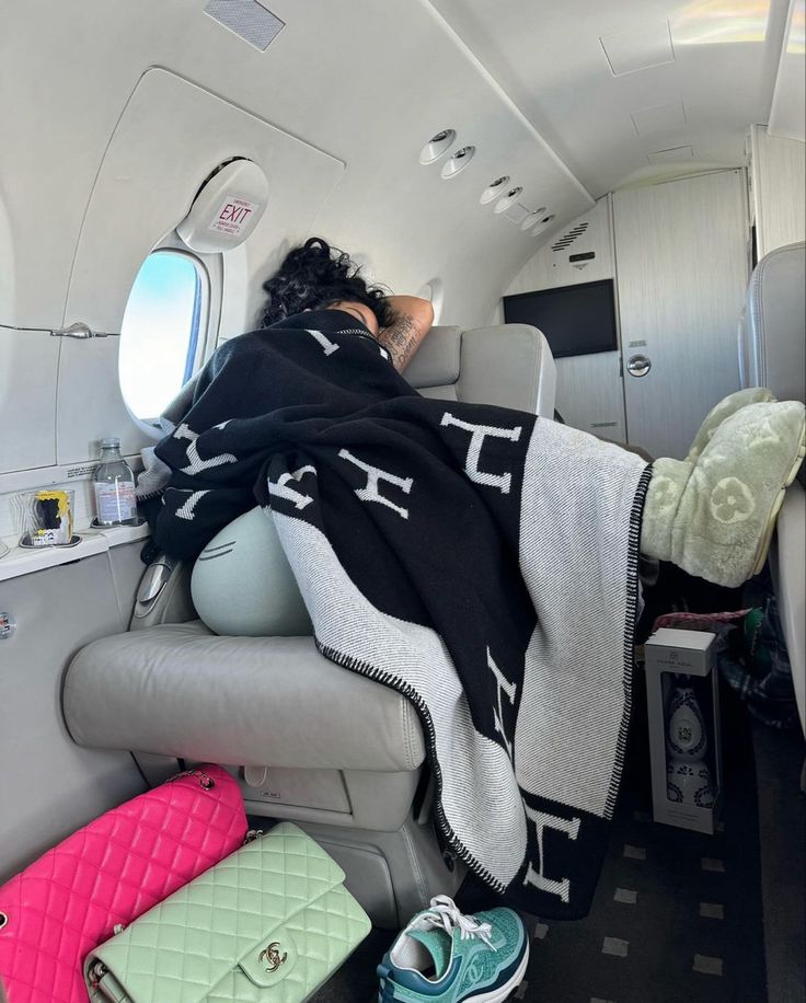 a woman is sleeping on an airplane with her head in the back of the seat