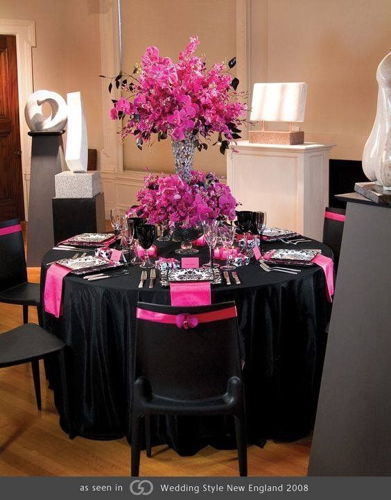 the table is set with black and pink decorations