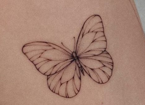 a small butterfly tattoo on the side of a woman's stomach, which is drawn in black ink