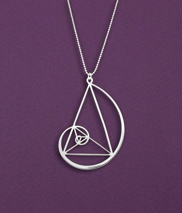 a silver necklace with an inverted triangle in the middle and a circle on it's side