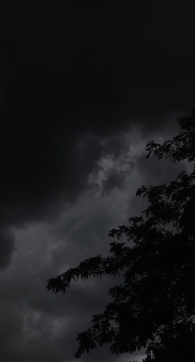 an airplane flying in the dark cloudy sky