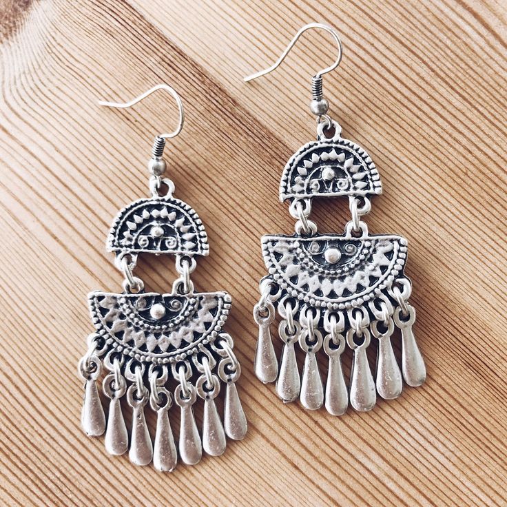 These vintage-inspired dangle earrings feature two half-moon fans filled with filigree detail, giving them captivating open spaces. Fringes on the bottom lend these chandelier earrings delightful movement and swing, adding a bohemian quality to the rustic and bright shine silver-tone finish. Shepherd's hooks keep these earrings in place. Handcrafted in Istanbul by local artisans Measurements: 5cm x 2.5cm Materials: Silver-plated zinc alloy Indian Jewelry Earrings, Boho Jewellery, Rustic Jewelry, Authentic Jewelry, Open Spaces, Gemstone Jewelry Handmade, Boho Gifts, Bohemian Earrings, Bohemian Fashion