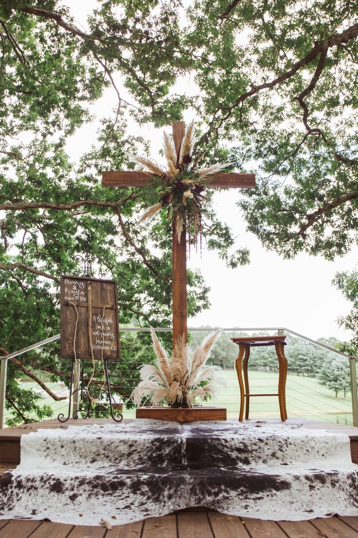 a wooden cross sitting on top of a lush green field