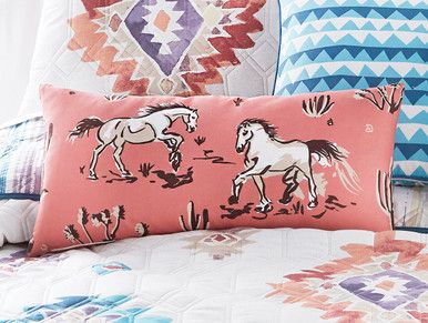 pillows with horses on them are sitting on a bed