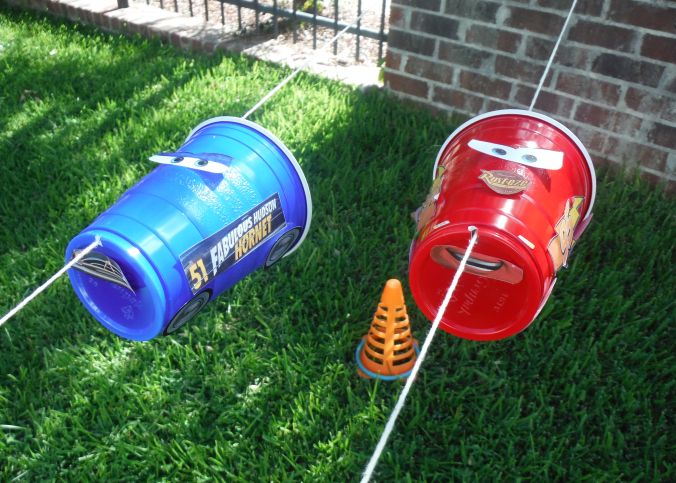 two red and blue mail boxes sitting on top of green grass next to a brick wall