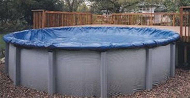 an above ground pool surrounded by gravel and trees