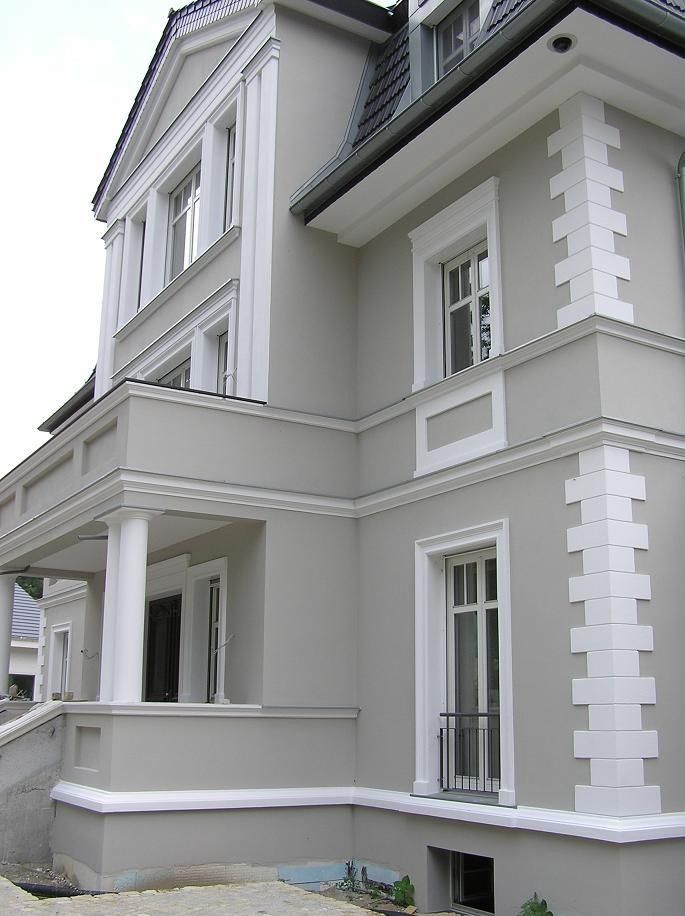 a large gray building with white trim and windows