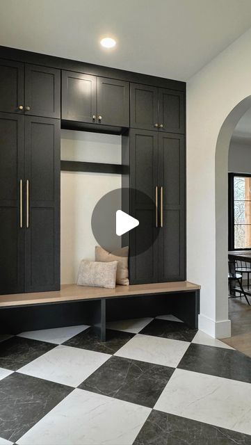 a black and white checkered floor in a room with cabinets on the wall, an entry way to another room