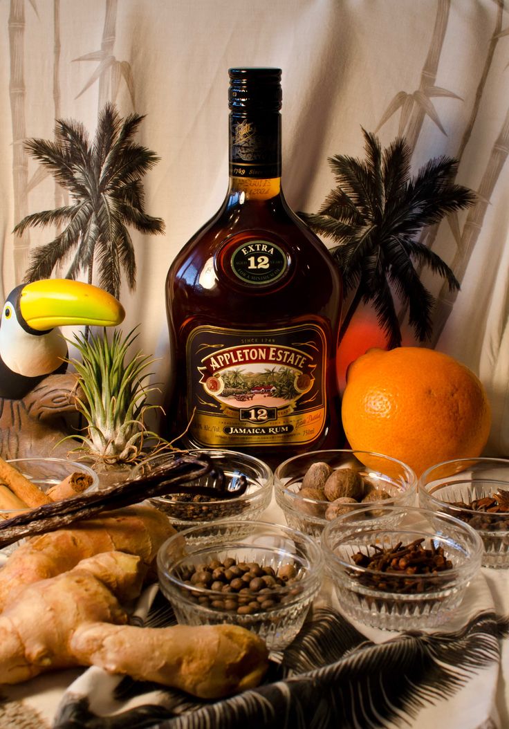 an assortment of food and drinks sitting on a table next to a bottle of alcohol