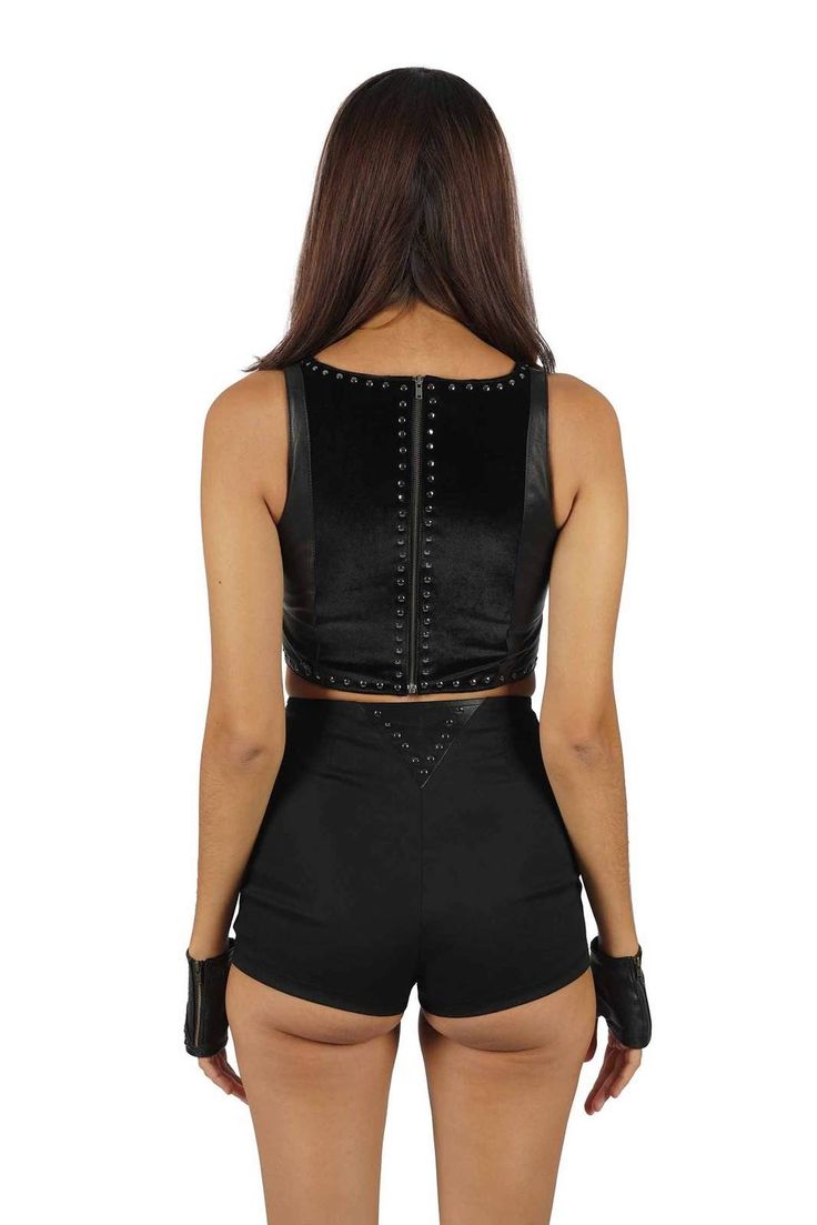 Unleash your inner rock star with the Victoria Leather Crop Top. This rebellious black studded top is more than a piece of clothing; it's a statement, an anthem, for those who march to the beat of their own drum. We love it styled with the Hendrix shorts and boots for any night you plan to see live music. FEATURES: Made with black goatskin leather and black velvet Hand studded with gun metal silver rivets Zipper back V neck Crop length Double layered for modesty & fully lined with black velvet A Edgy Black Crop Top For Concert, Gothic Crop Top For Concerts, Punk Style Party Crop Top, Black Punk Crop Top For Night Out, Punk Style Black Crop Top For Night Out, Edgy Black Crop Top For Festival, Black Punk Crop Top For Festival, Black Punk Style Crop Top For Festival, Rocker Style Top For Night Out